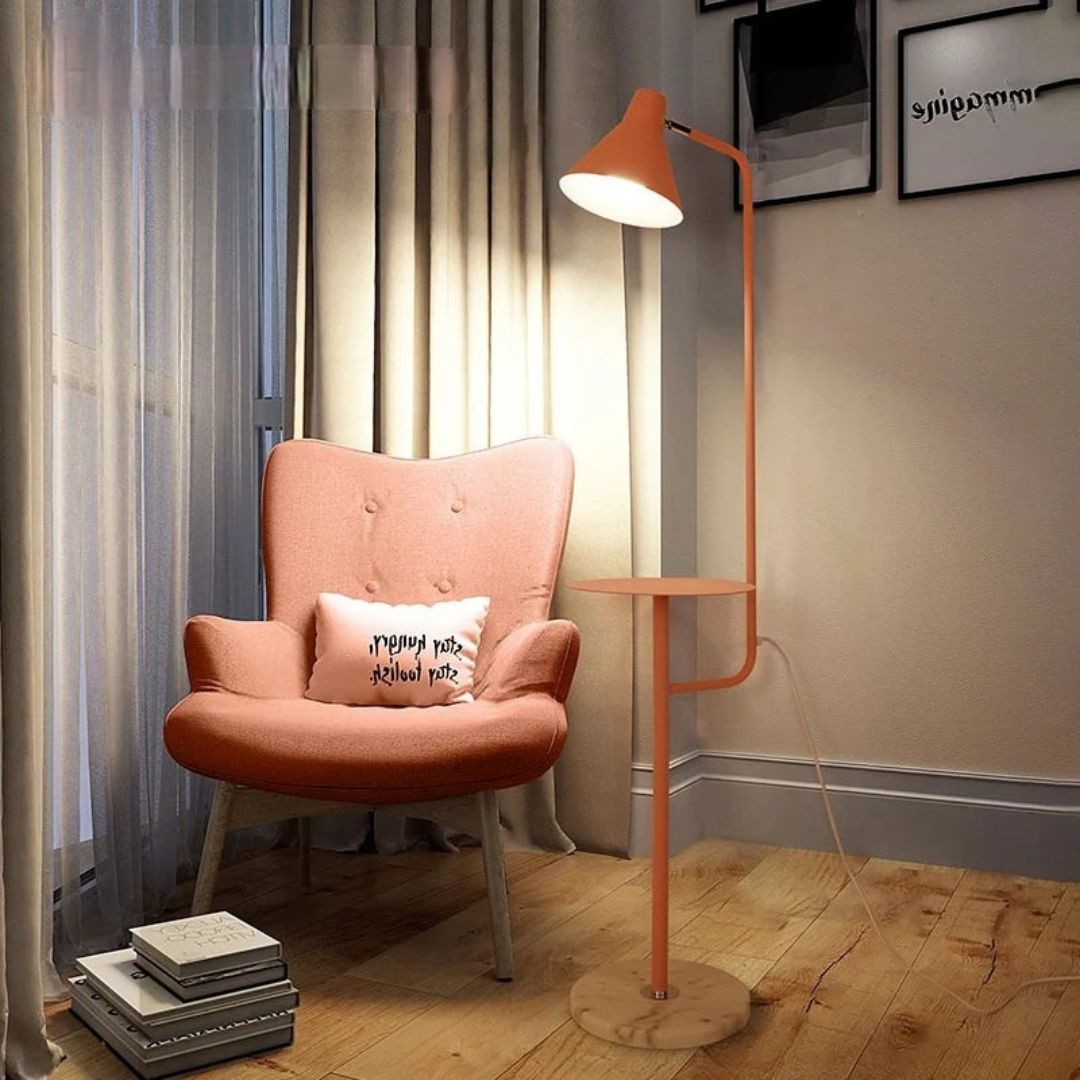 Lámpara de pie con mesita integrada Somesa – en rosa junto a un sillón