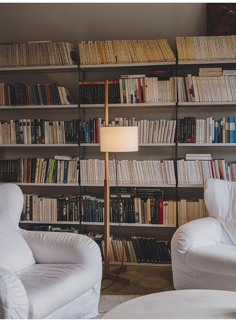 Lámpara de pie de madera Rasela – junto a una librería