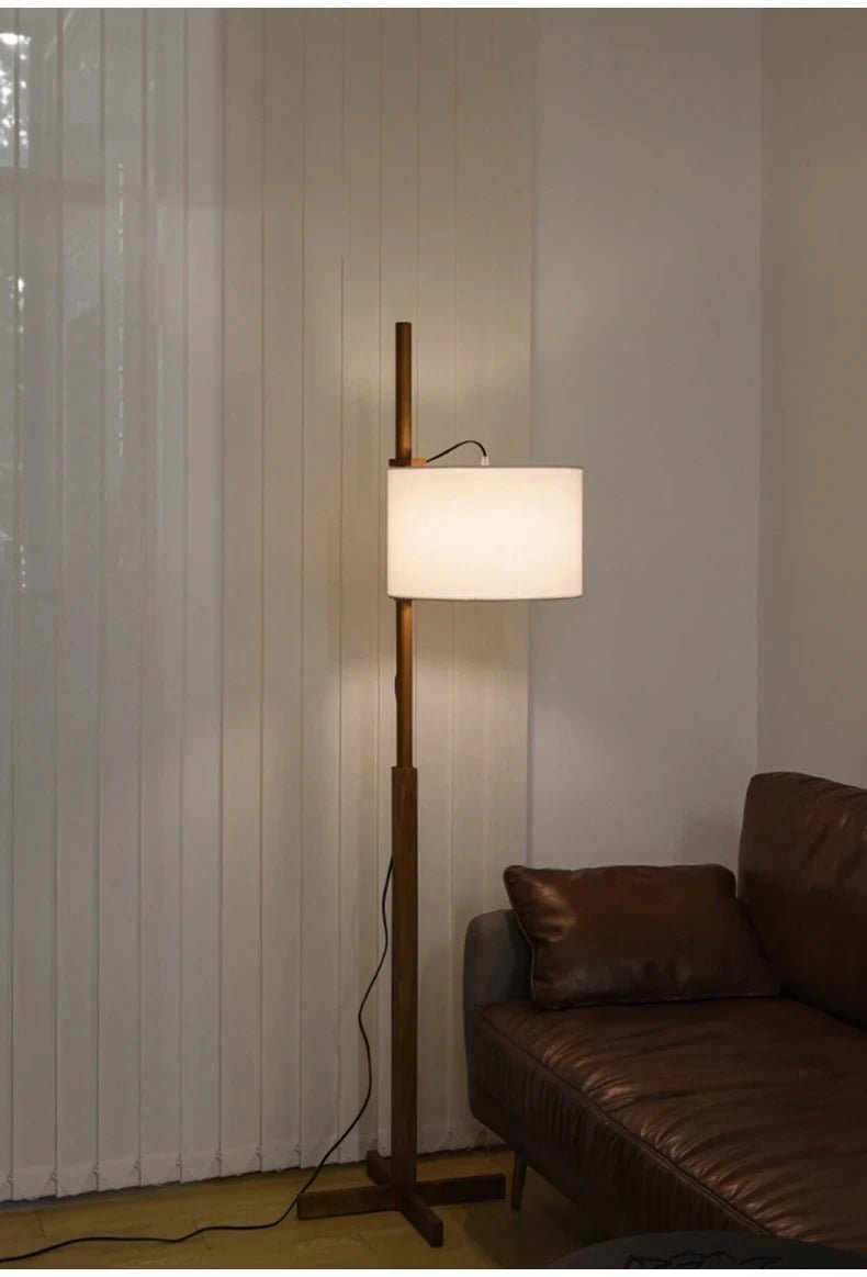 Lámpara de pie de madera Rasela – junto a un sofá de cuero