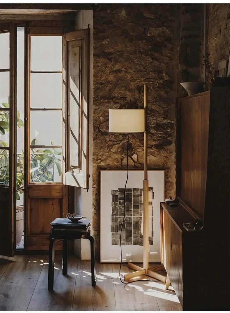 Lámpara de pie de madera Rasela – en un estudio con paredes de piedra