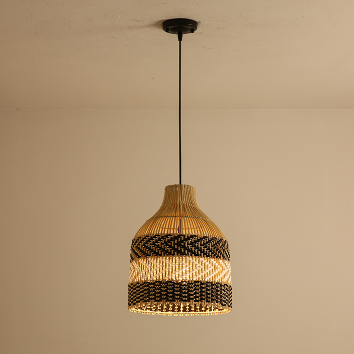 Lámpara colgante de ratán Docela – encendida con luz cálida