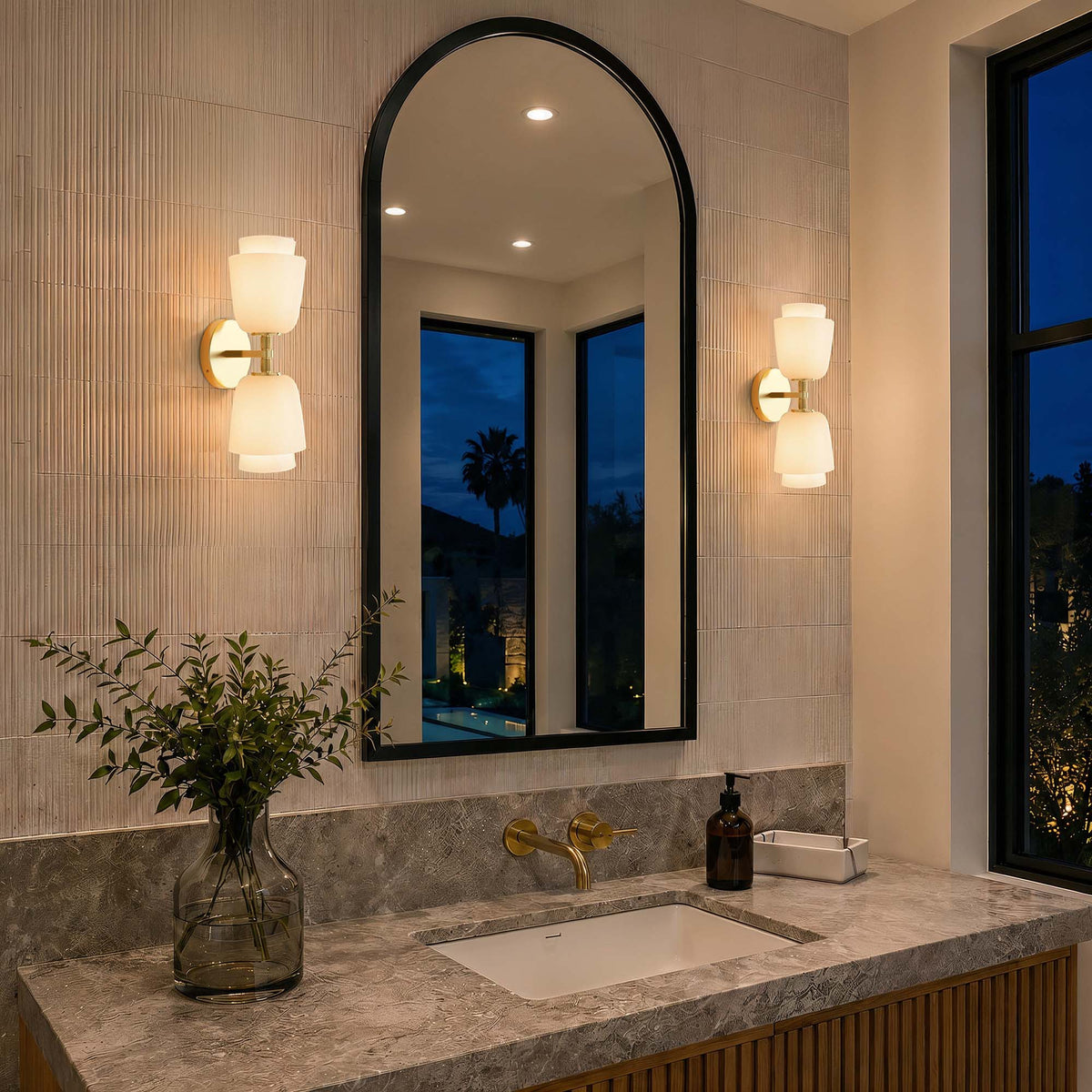 Aplique de pared doble de latón con campanas de cristal Purela – en un baño al anochecer