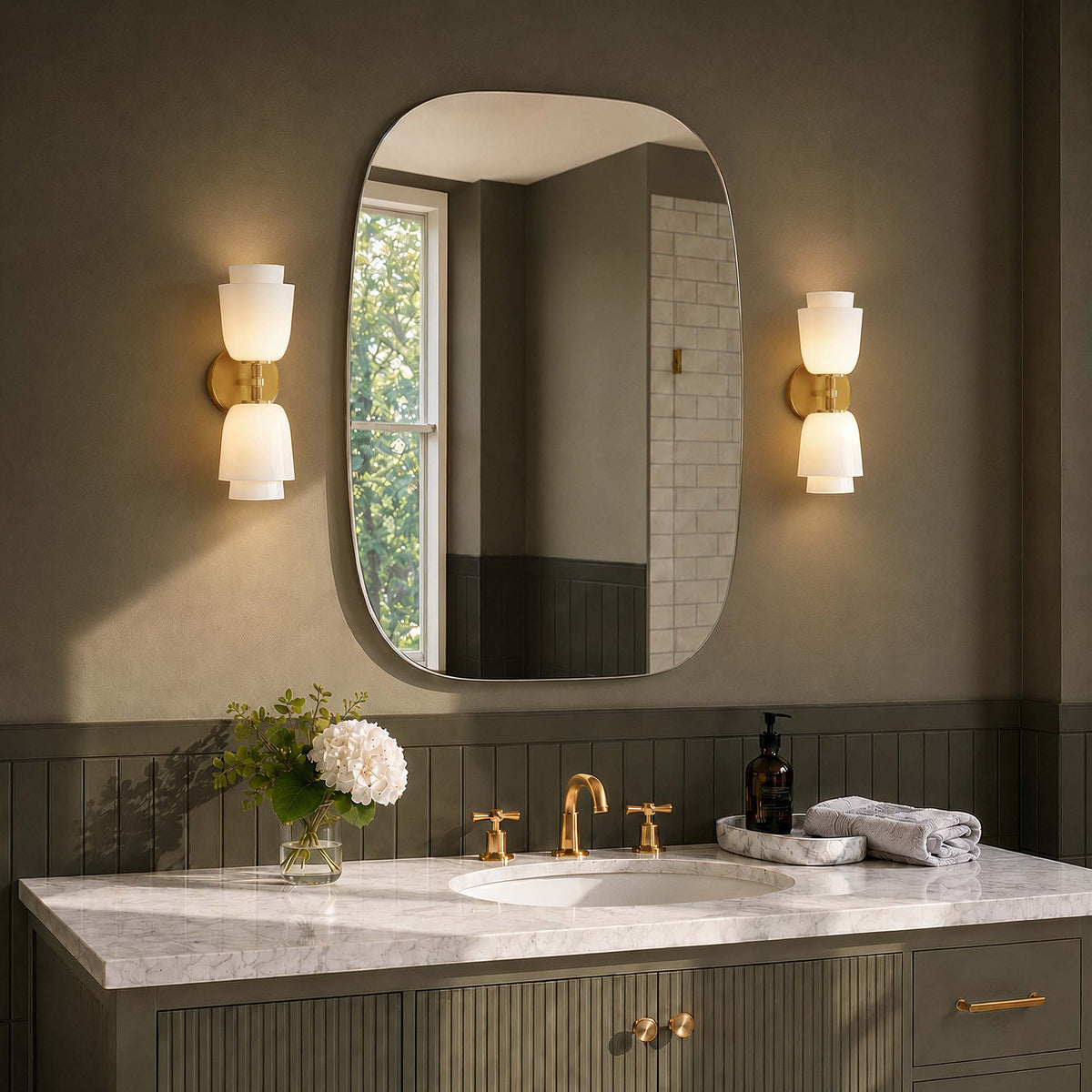 Aplique de pared doble de latón con campanas de cristal Purela – pareja junto al espejo de un baño verde salvia
