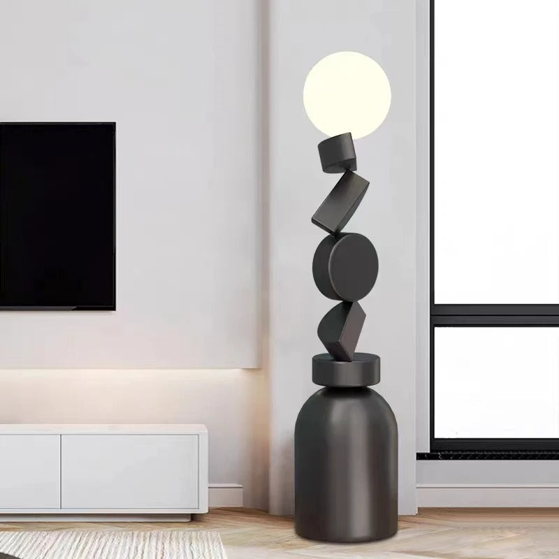 Lámpara de pie escultural Pedrina con formas apiladas – en un salón con televisor