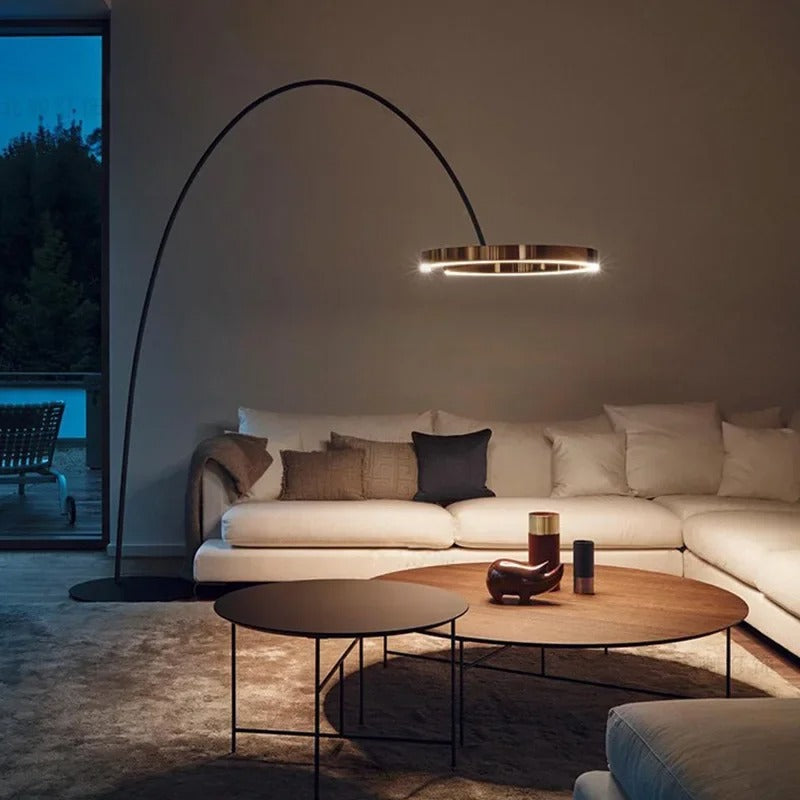 Lámpara de pie arco LED Pamira con aro de luz – encendida sobre una mesa de centro