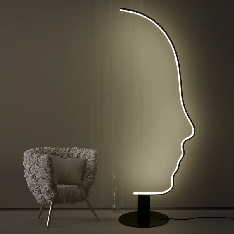 Lámpara de pie LED con silueta de rostro Quiara – junto a una butaca