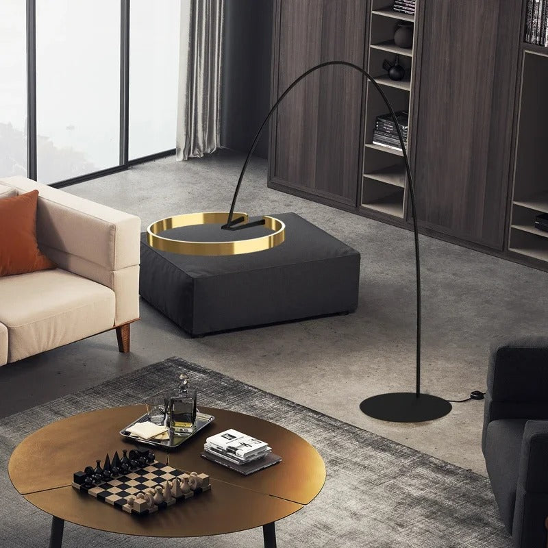 Lámpara de pie arco LED Pamira con aro de luz – aro dorado sobre una mesa baja