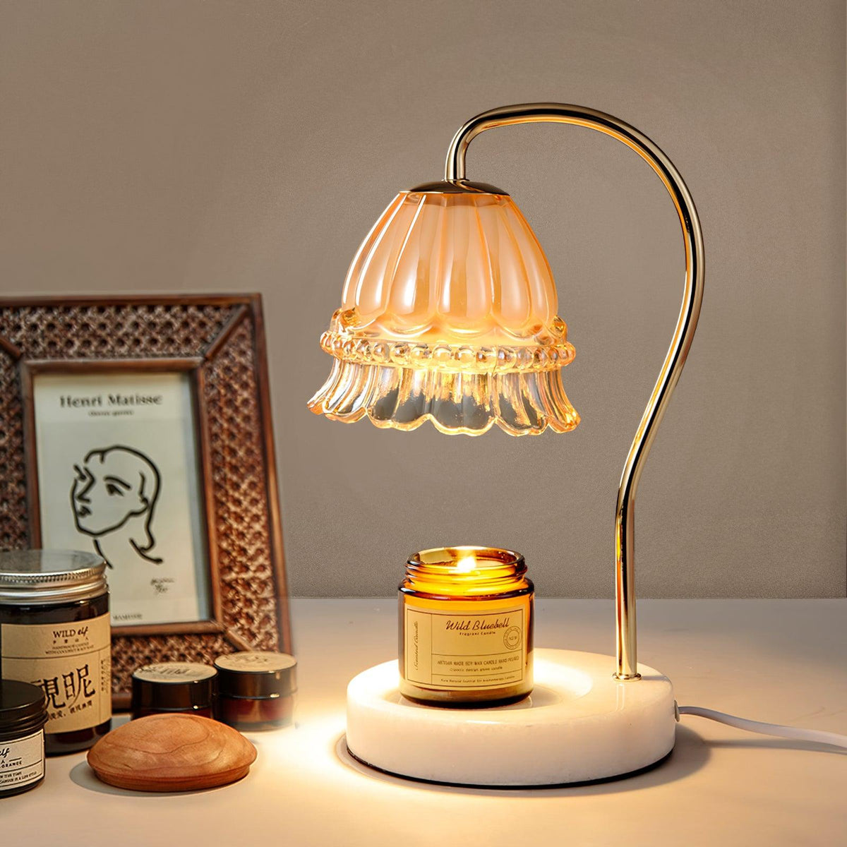 Lámpara de mesa calientavelas de cristal y mármol Miela sobre un escritorio junto a una vela aromática – imagen 7