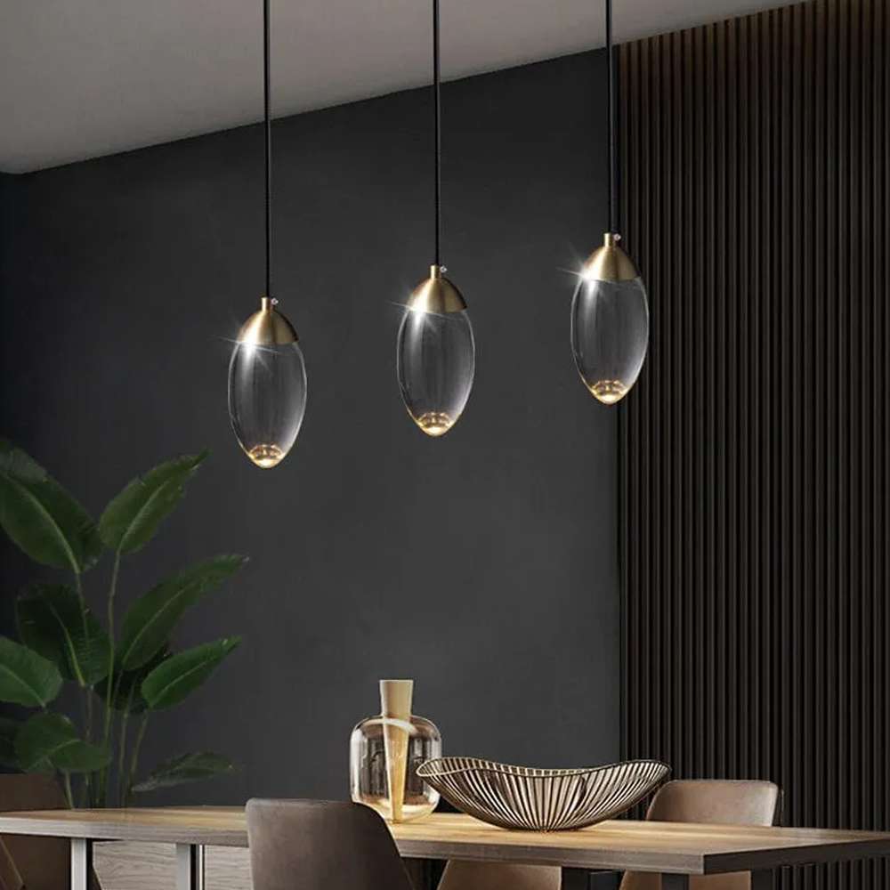Lámpara colgante de cristal K9 y latón Helira – tres lámparas sobre una mesa de comedor
