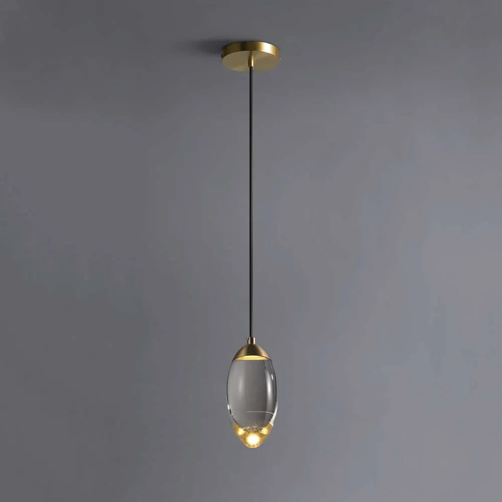 Lámpara colgante de cristal K9 y latón Helira – encendida sobre fondo gris