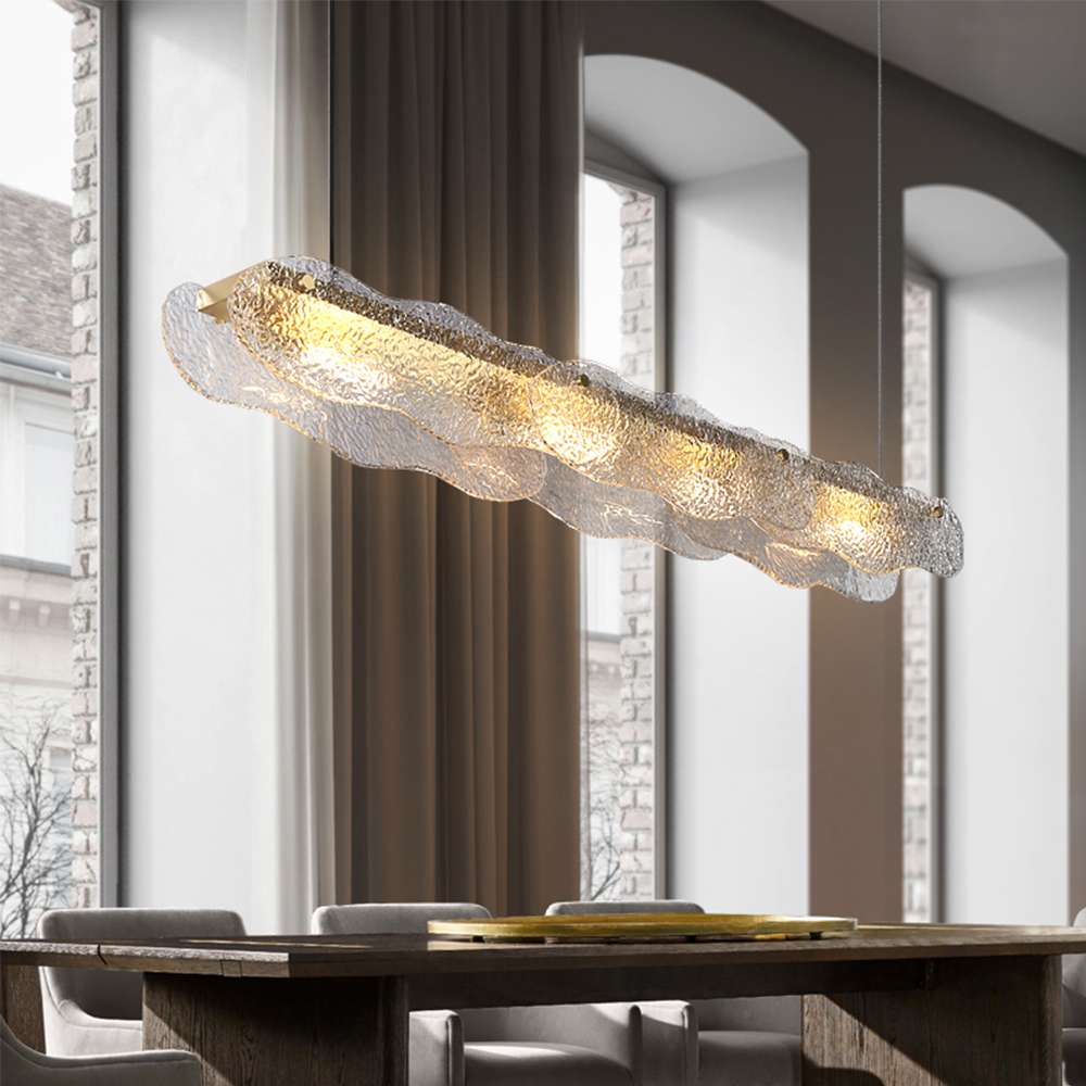 Lámpara colgante lineal de cristal ondulado Brumara – en un comedor con grandes ventanales