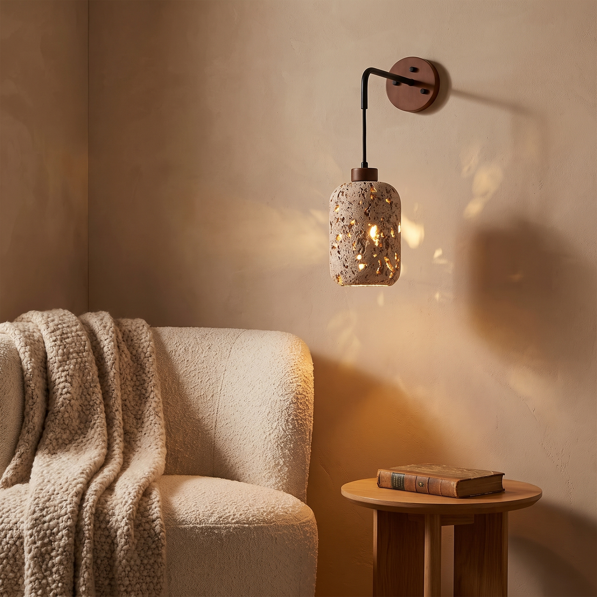 Aplique de pared Uporia de travertino perforado – junto a un sillón de lectura