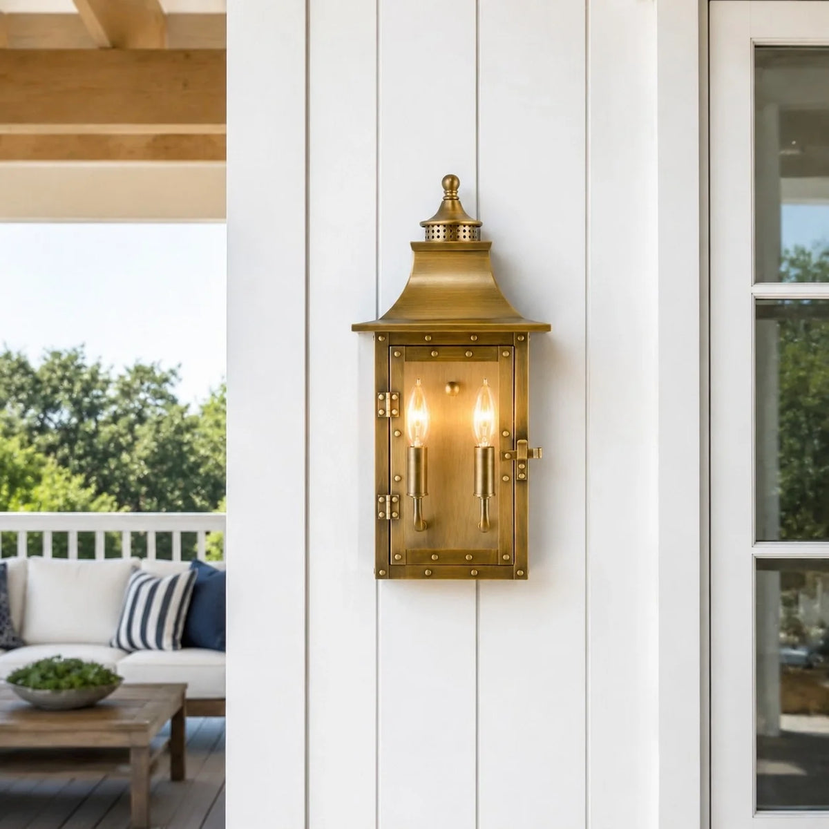 Farol de pared exterior Ocandia – en latón en un porche blanco