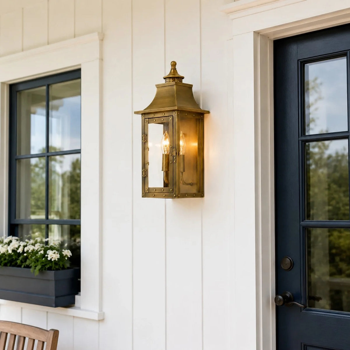 Farol de pared exterior Ocandia – en latón junto a una ventana