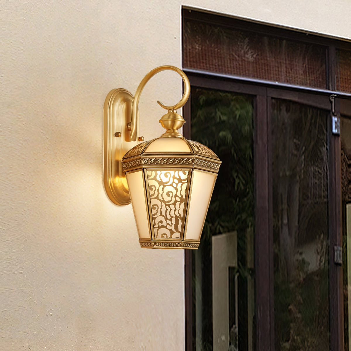 Farol de pared exterior de latón Ofelma – junto a una puerta de cristal