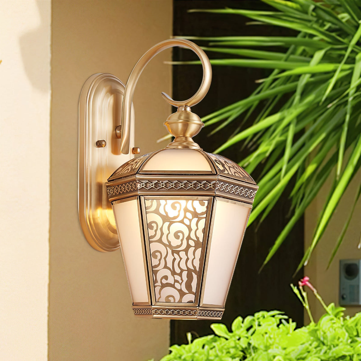 Farol de pared exterior de latón Ofelma – junto a una palmera