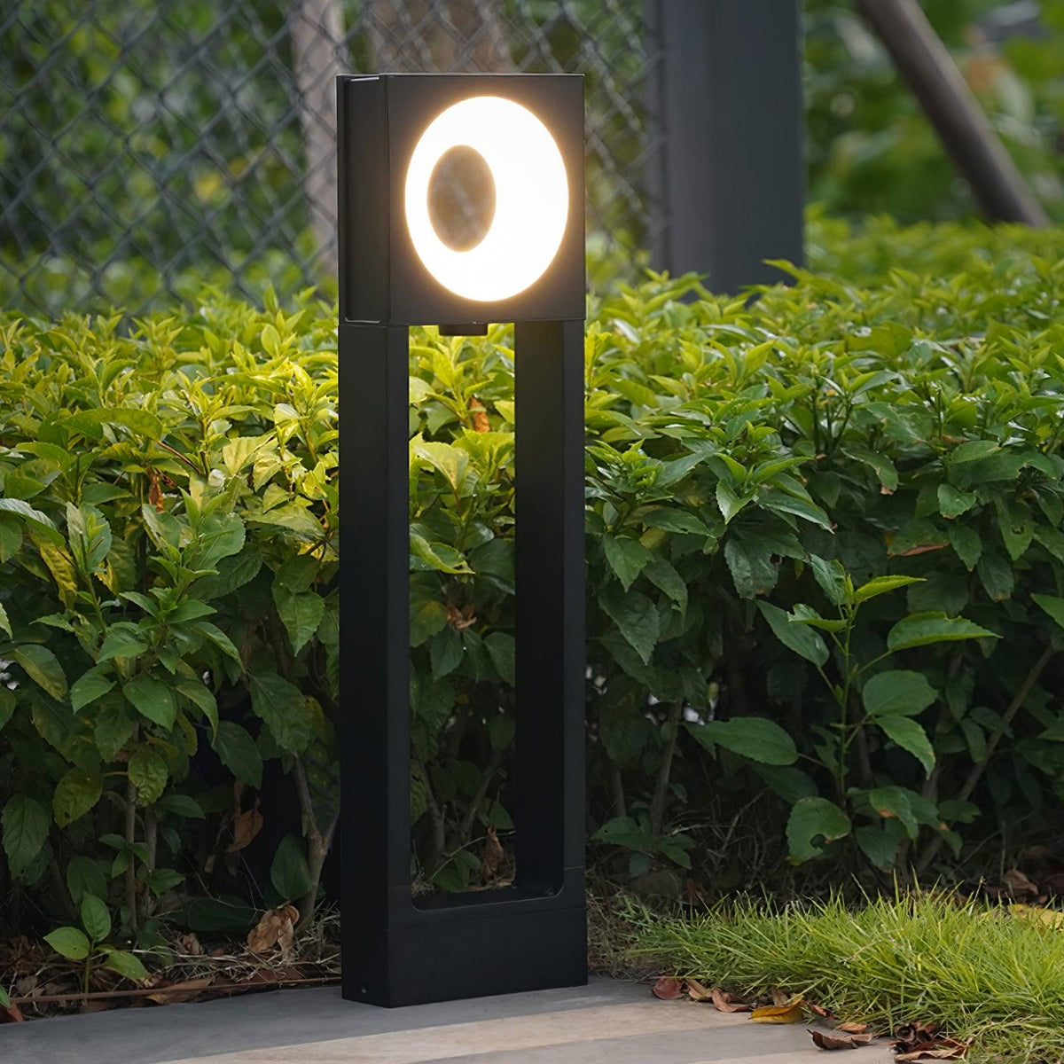 Baliza de jardín LED Oliano – remate cuadrado encendido en un jardín
