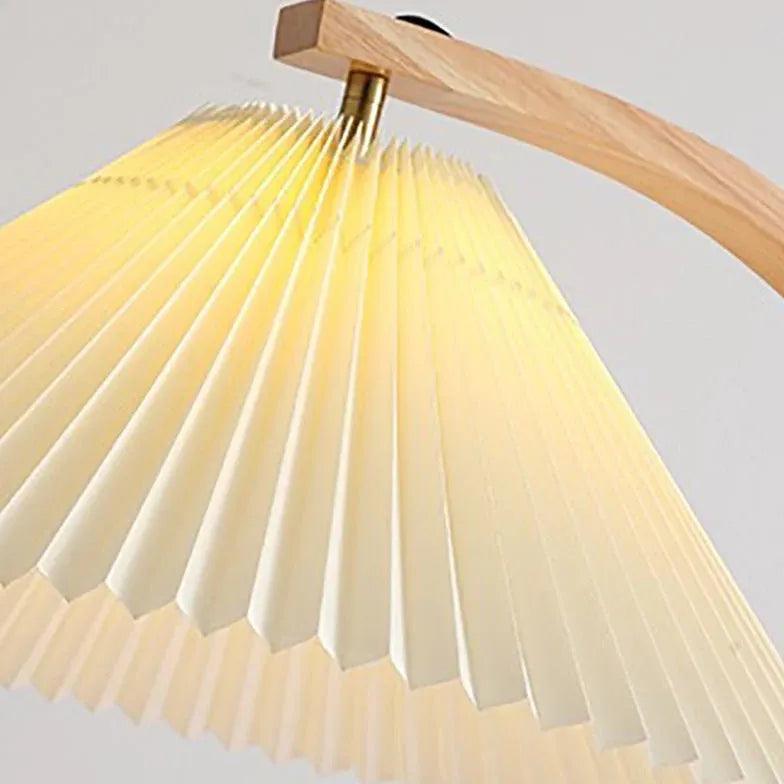 Lámpara de pie de madera con mesita auxiliar y pantalla plisada Hilvia – detalle de la pantalla plisada y el brazo de madera