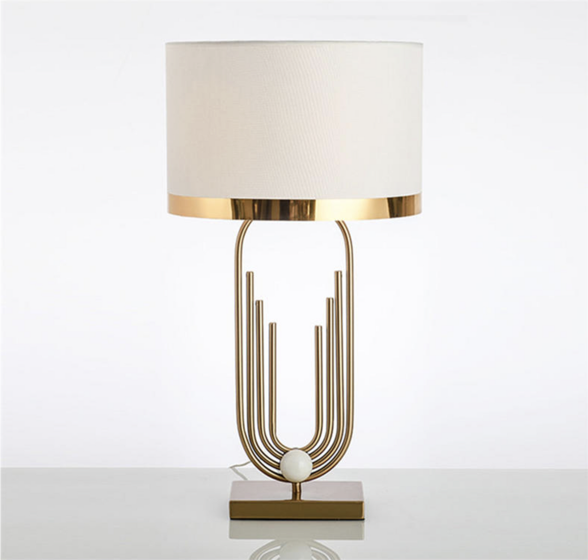 Lámpara de mesa art déco dorada Polena sobre una mesita junto al sofá – imagen 15