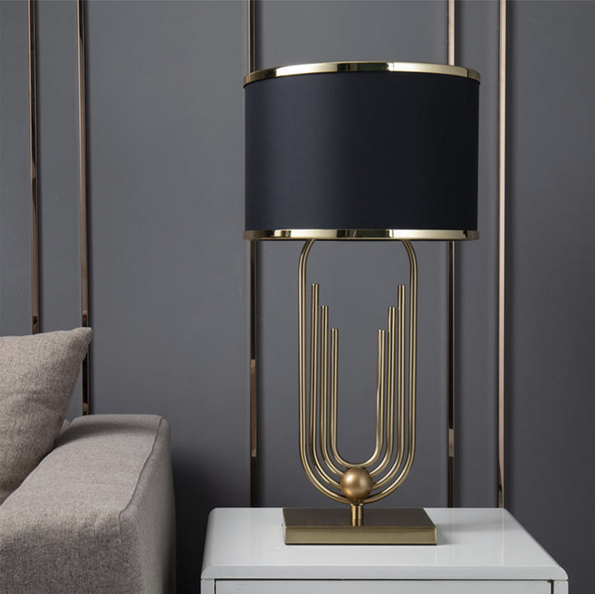 Lámpara de mesa art déco dorada Polena sobre una mesita junto al sofá – imagen 16