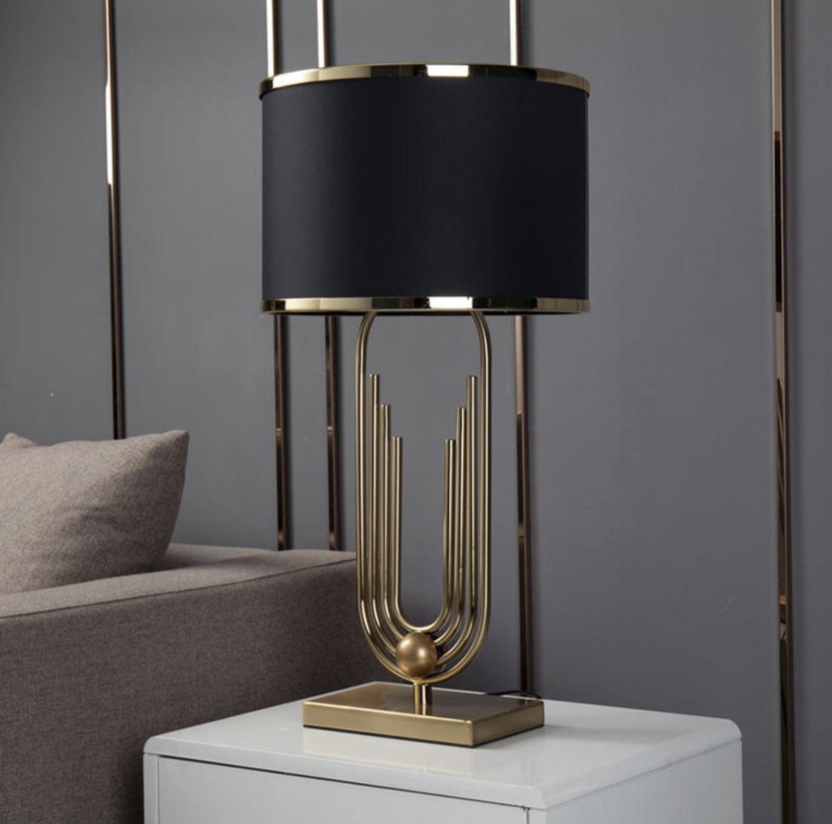 Lámpara de mesa art déco dorada Polena sobre una mesita junto al sofá – imagen 18