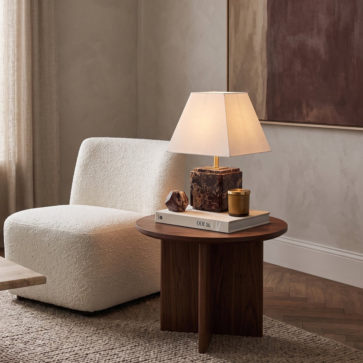 Lámpara de mesa de mármol Quadrela – junto a un sillón de bouclé