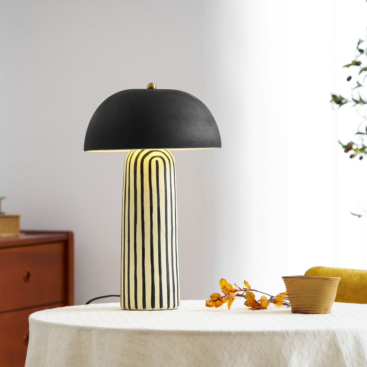 Lámpara de mesa de cerámica a rayas Rayola – encendida en un comedor