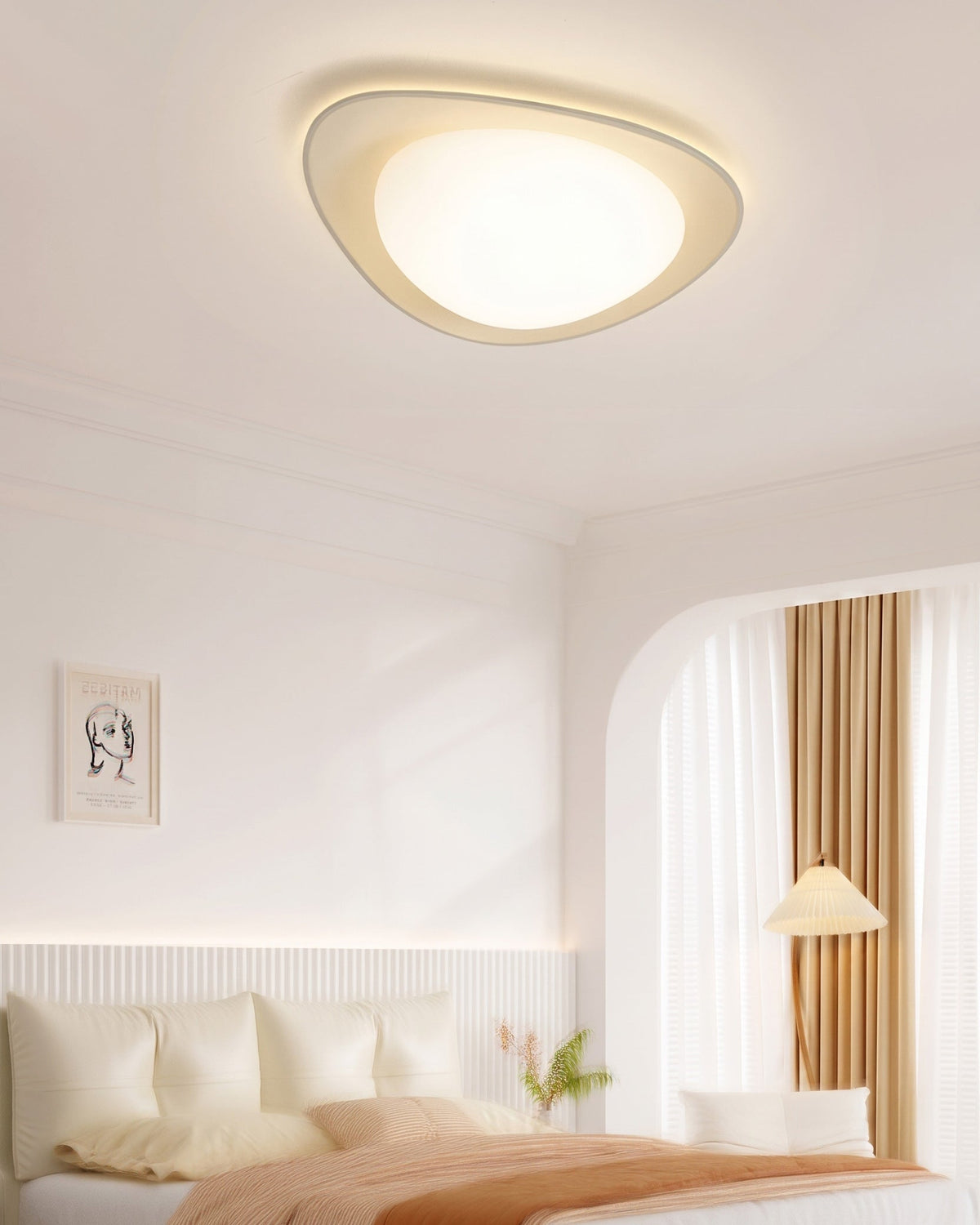 Plafón LED en forma de canto rodado Cantela – encendido sobre una cama