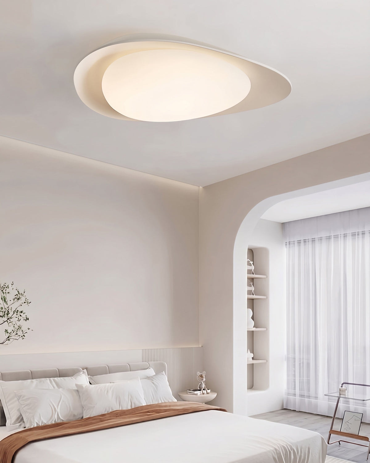 Plafón LED en forma de canto rodado Cantela – sobre una cama de matrimonio