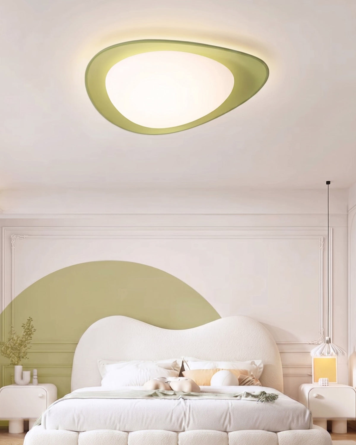 Plafón LED en forma de canto rodado Cantela – con aro verde sobre un cabecero