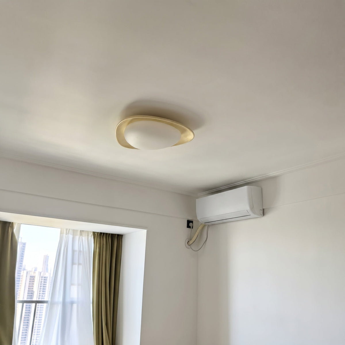 Plafón LED en forma de canto rodado Cantela – en un dormitorio con ventanal