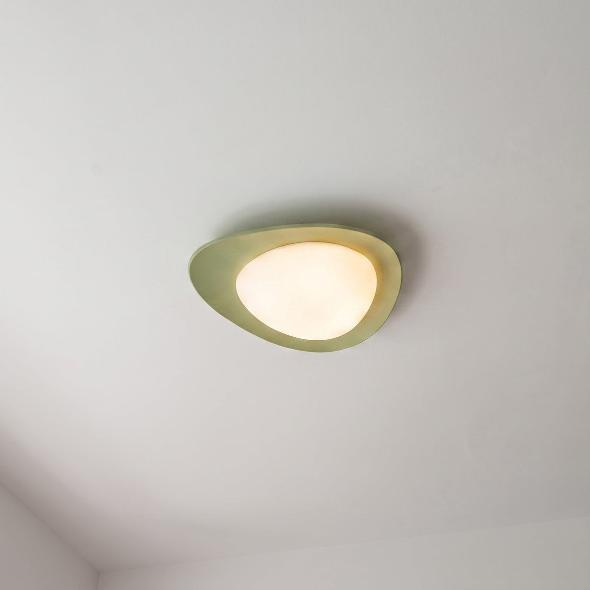 Plafón LED en forma de canto rodado Cantela – con aro verde en el techo