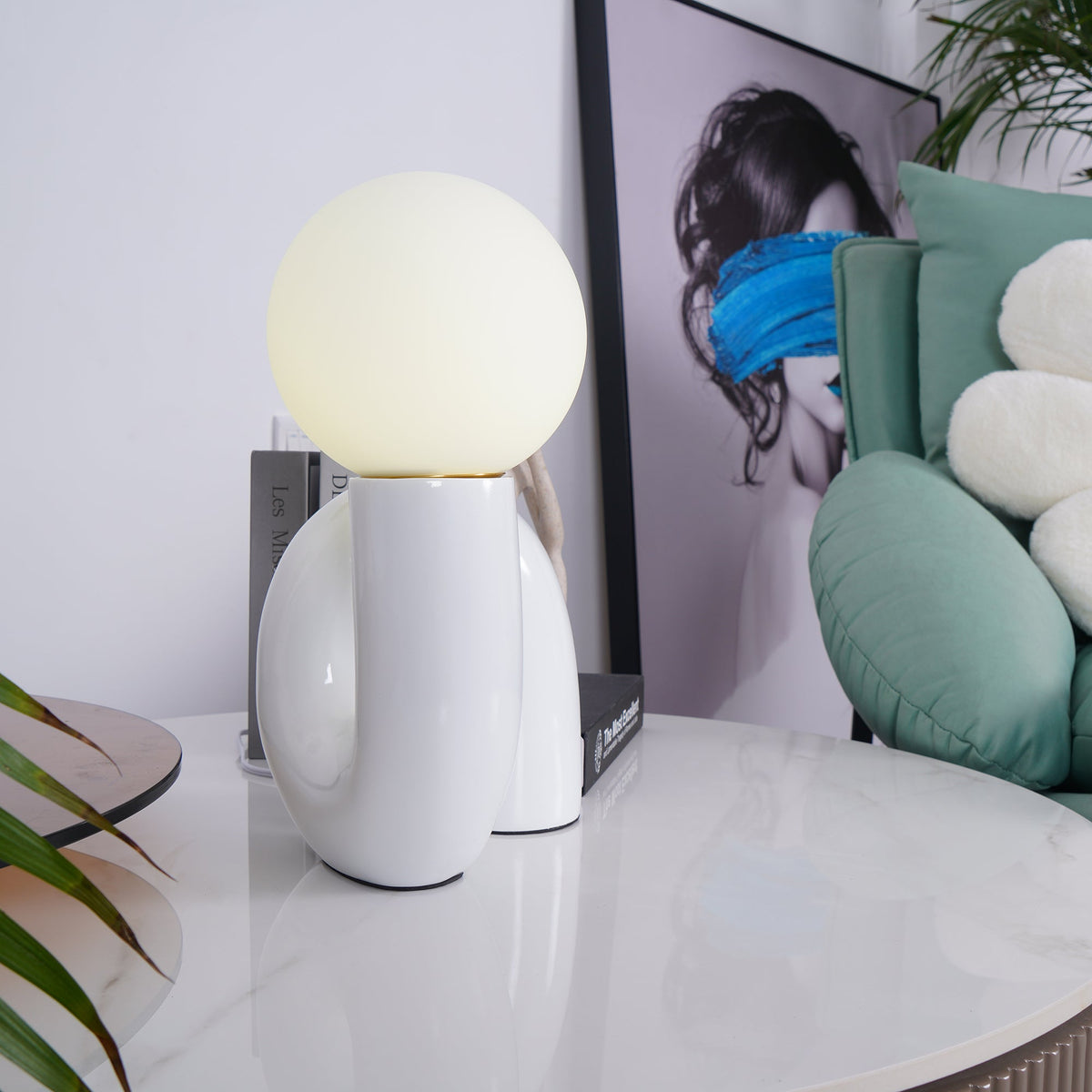 Lámpara de mesa escultural Rizeta – blanca junto a un sofá