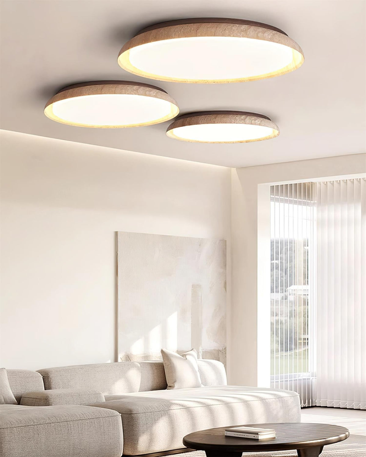 Plafón LED de techo Calerra con aro de travertino – tres tamaños en un salón