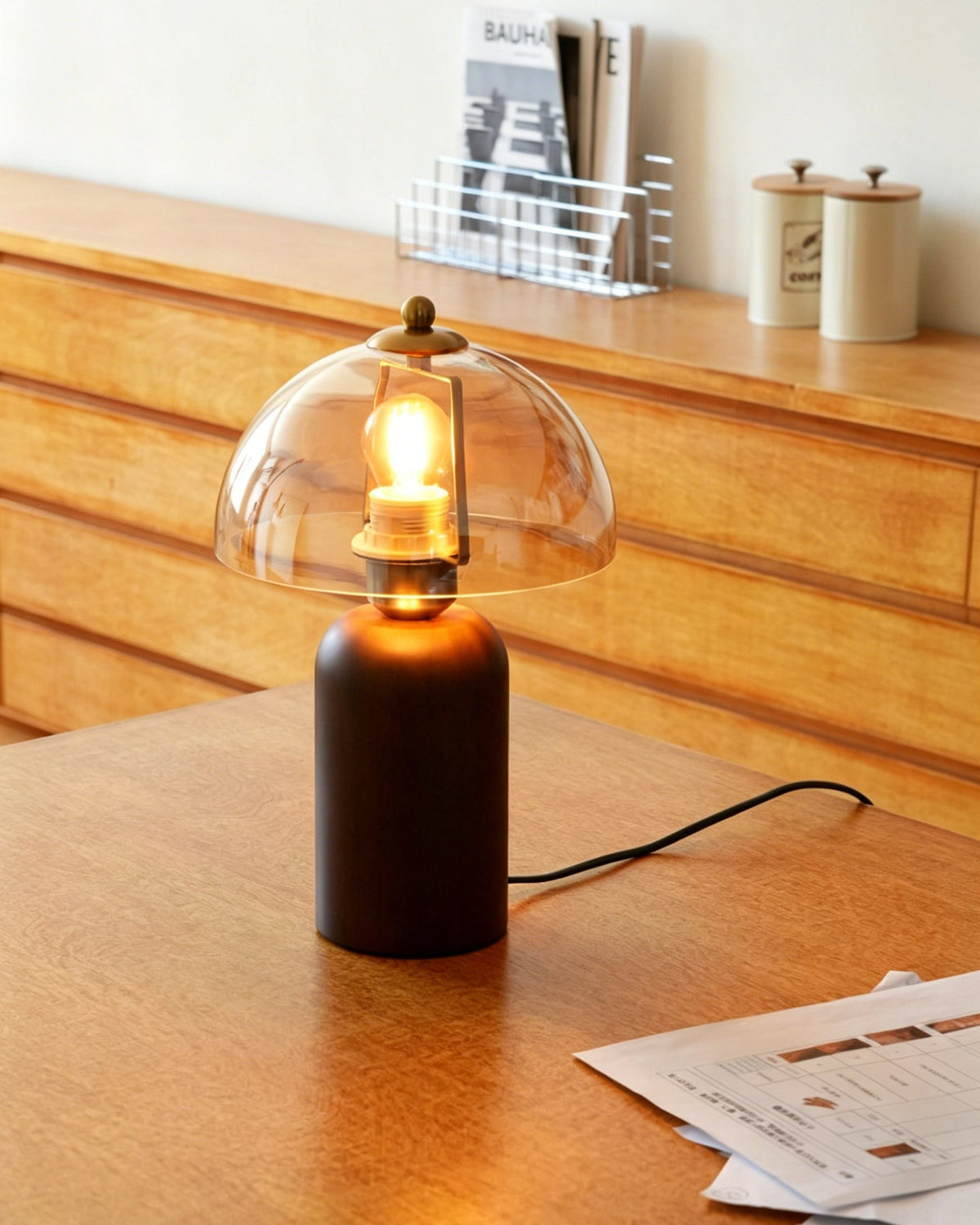 Lámpara de mesa de madera y cristal ámbar Rubana – encendida sobre un escritorio de madera