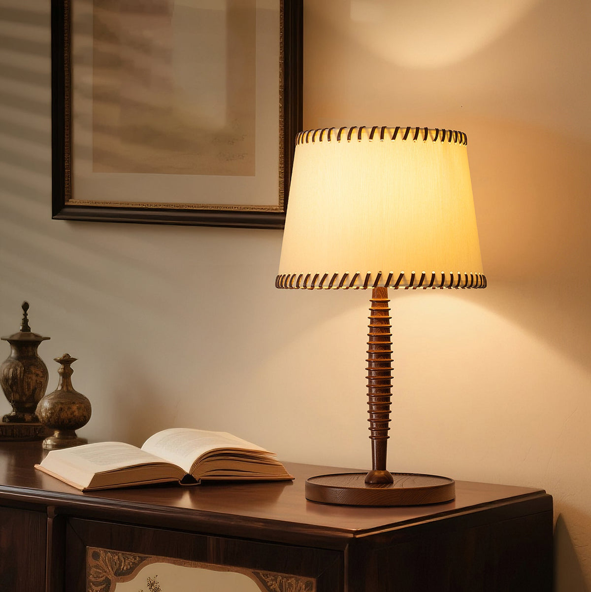 Lámpara de mesa de madera torneada Rueca – encendida sobre una cómoda