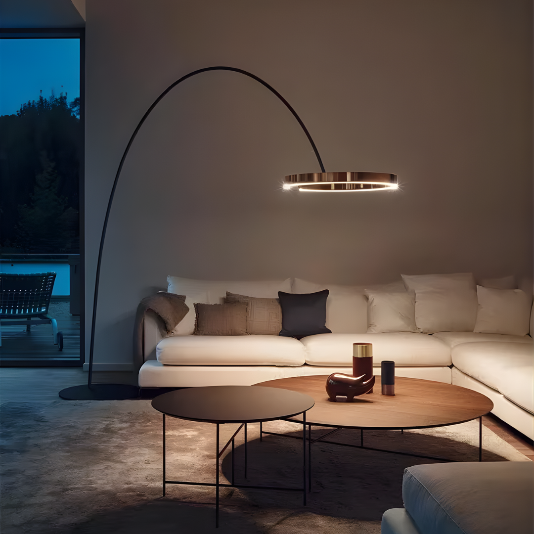 Lámpara de pie arco Ruedana – aro LED oro rosa sobre un sofá