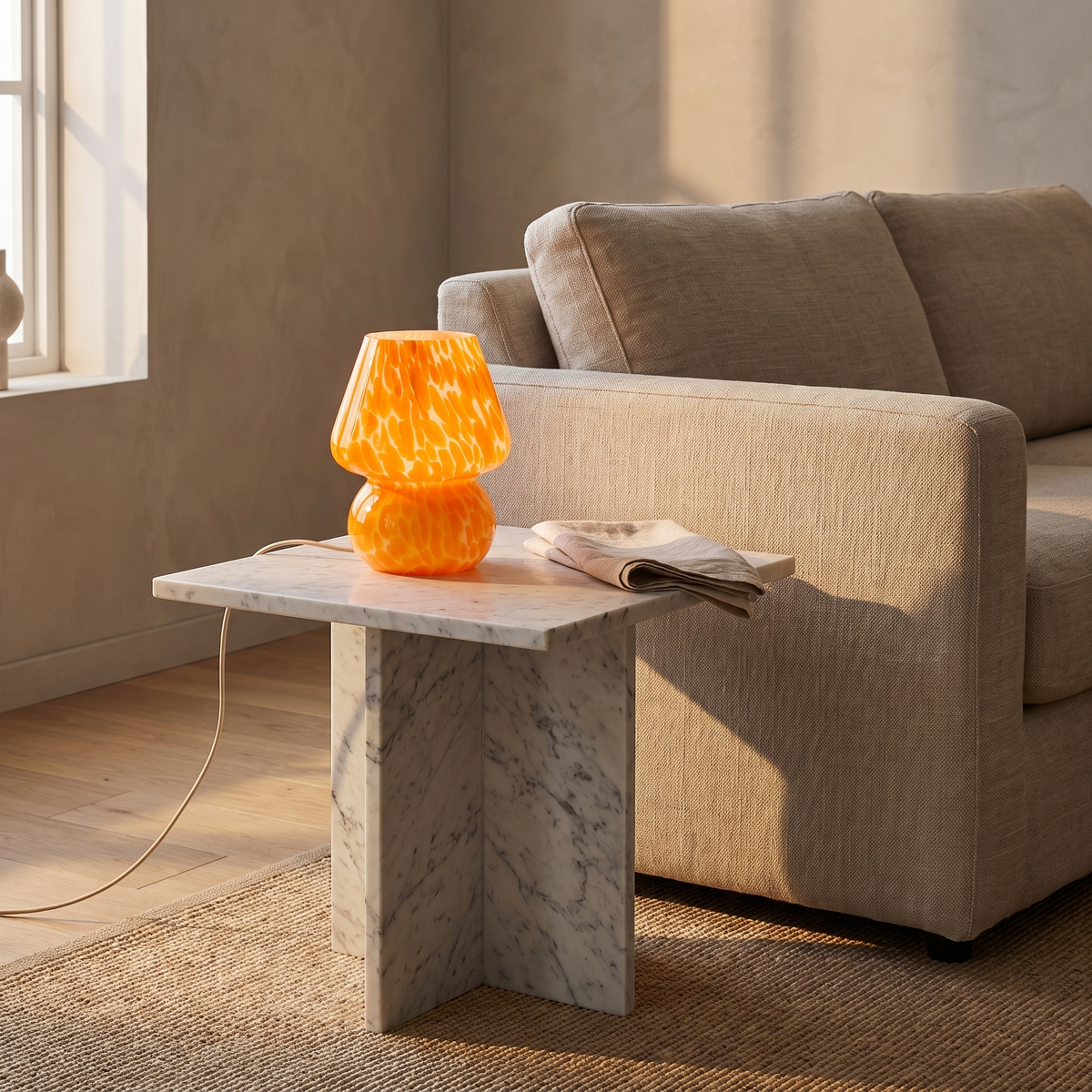 Lámpara de mesa seta de cristal Salpina – naranja sobre una mesa auxiliar de mármol
