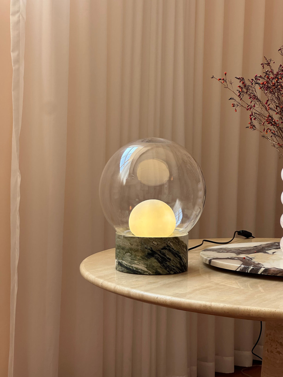 Lámpara de mesa de cristal Saquira – encendida en un rincón