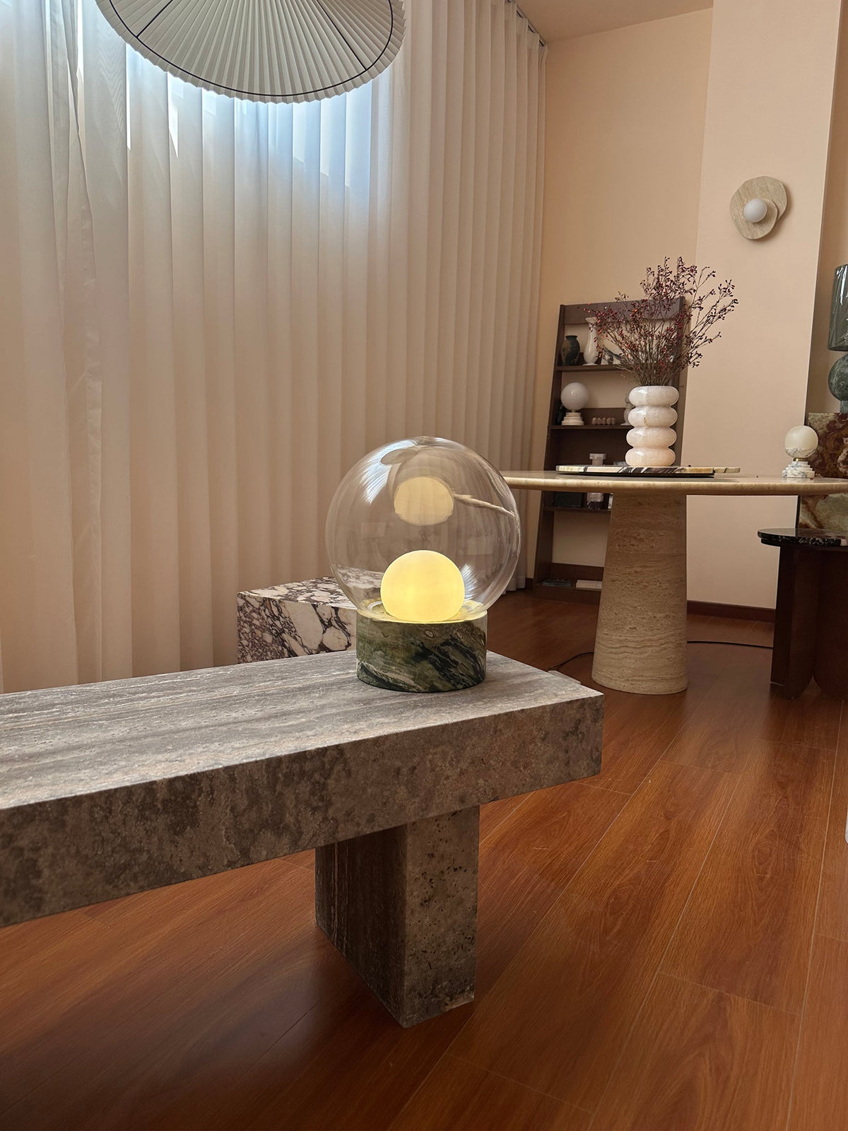 Lámpara de mesa de cristal Saquira – en un salón con cortinas