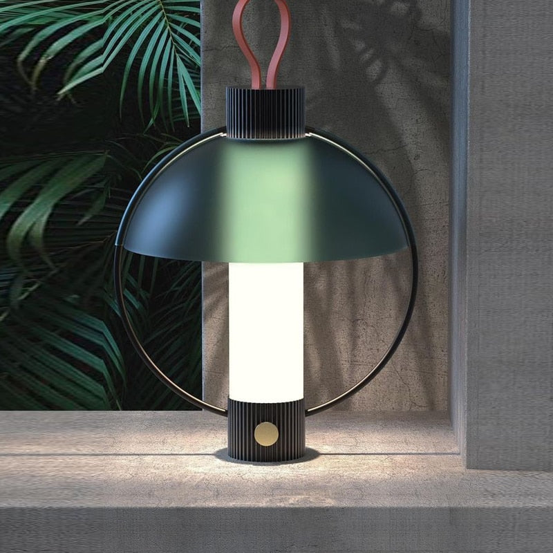 Lámpara de mesa farol Saturna – encendida junto a plantas