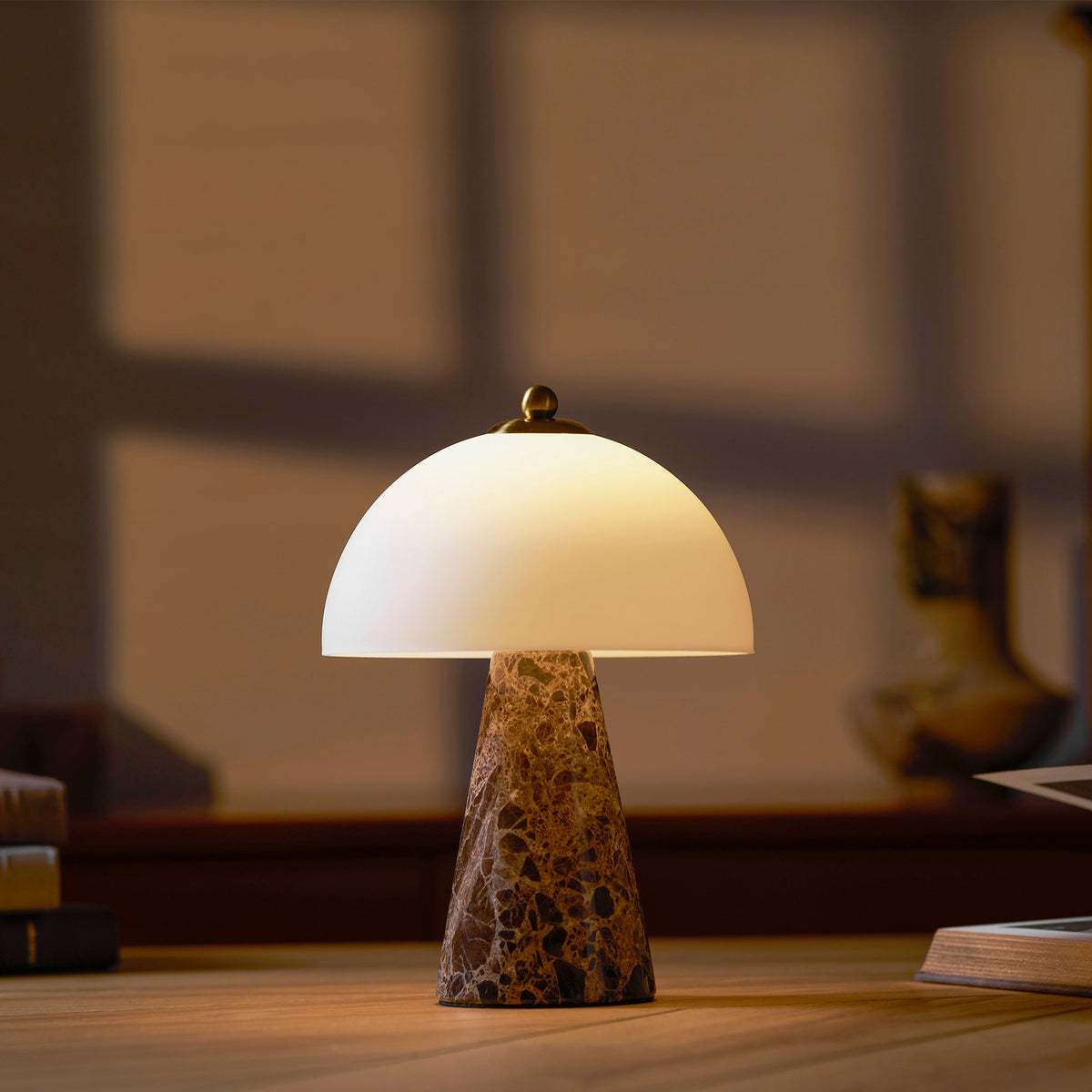 Lámpara de mesa de mármol Selune – encendida sobre una mesa de madera