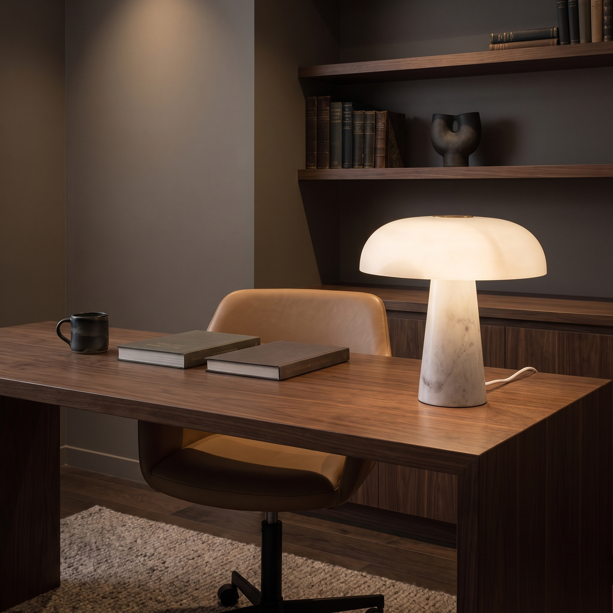 Lámpara de mesa de mármol Setalma – encendida sobre un escritorio de nogal