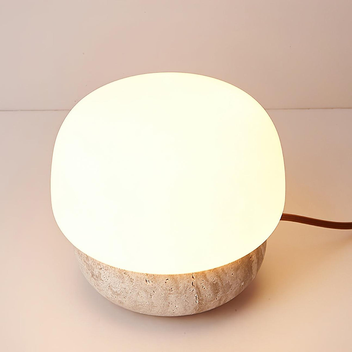 Lámpara de mesa de travertino Setina – encendida con luz cálida