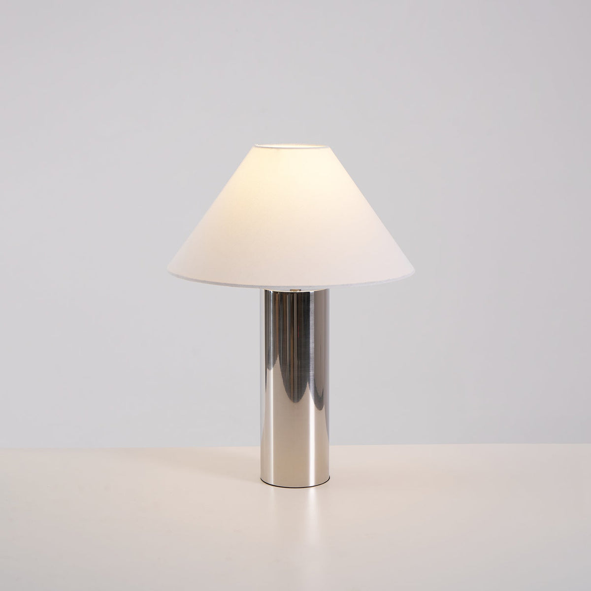 Lámpara de mesa cromada Silvera – encendida con luz cálida