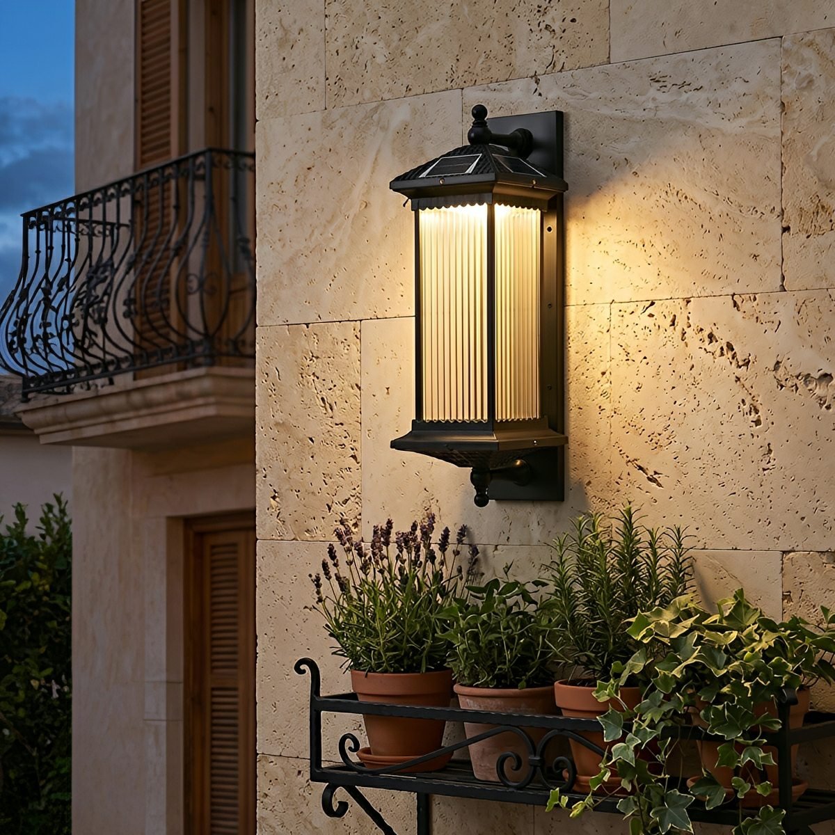 Farol solar de pared exterior Iorena – en una fachada de piedra con balcón