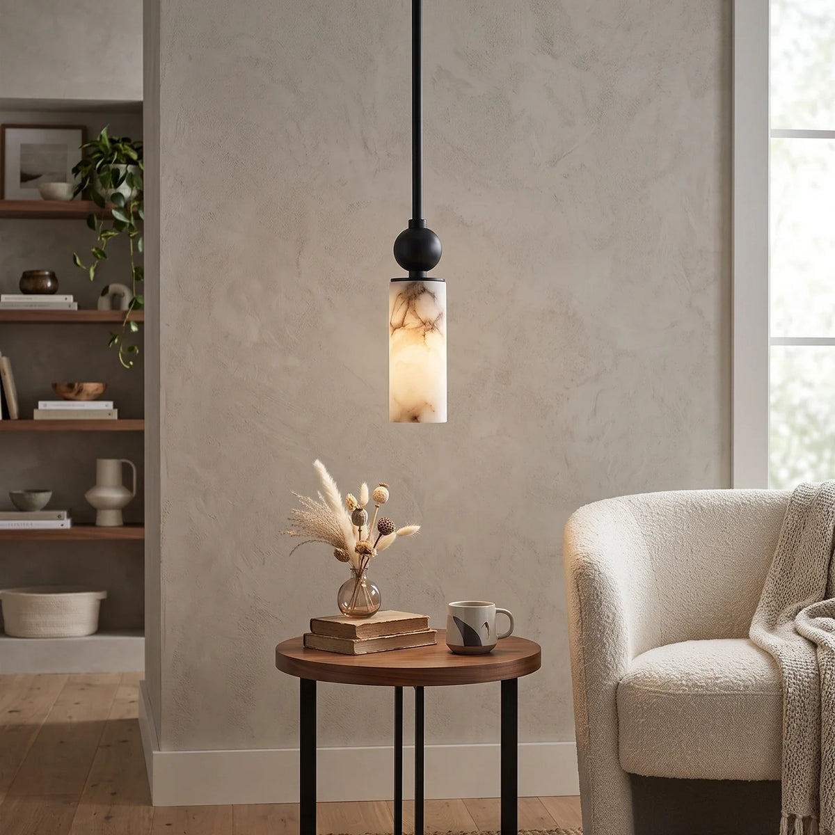 Lámpara colgante de alabastro Cerilda – en negro junto a un sillón