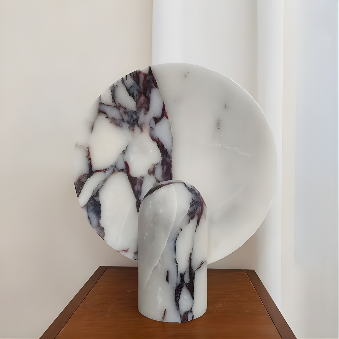 Lámpara de mesa de piedra Solsticia – en mármol Calacatta Viola junto a una ventana