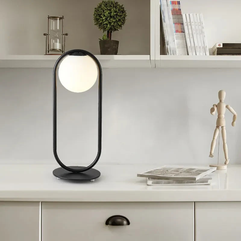 Lámpara de mesa con globo opal Sortela – en una estantería luminosa