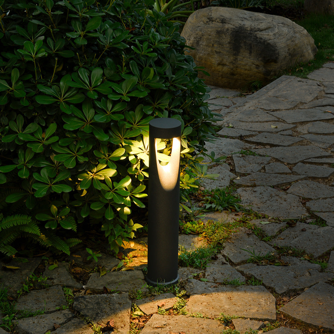 Baliza de jardín LED Jelvara – encendida junto a rocas y vegetación